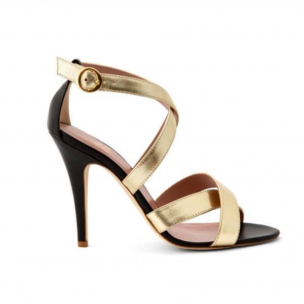 Two-tone high heeled sandal, made of black nappa and intertwined with soft platinum laminate bands that gently wrap around the foot, then closed by the strap with side buckle at the ankle