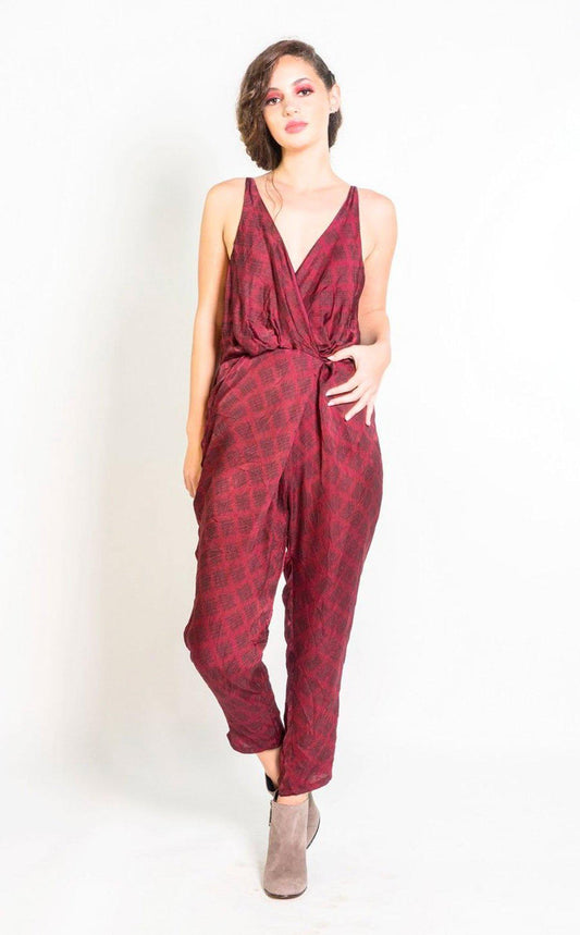 Woman wearing a red patterned jumpsuit on a white background